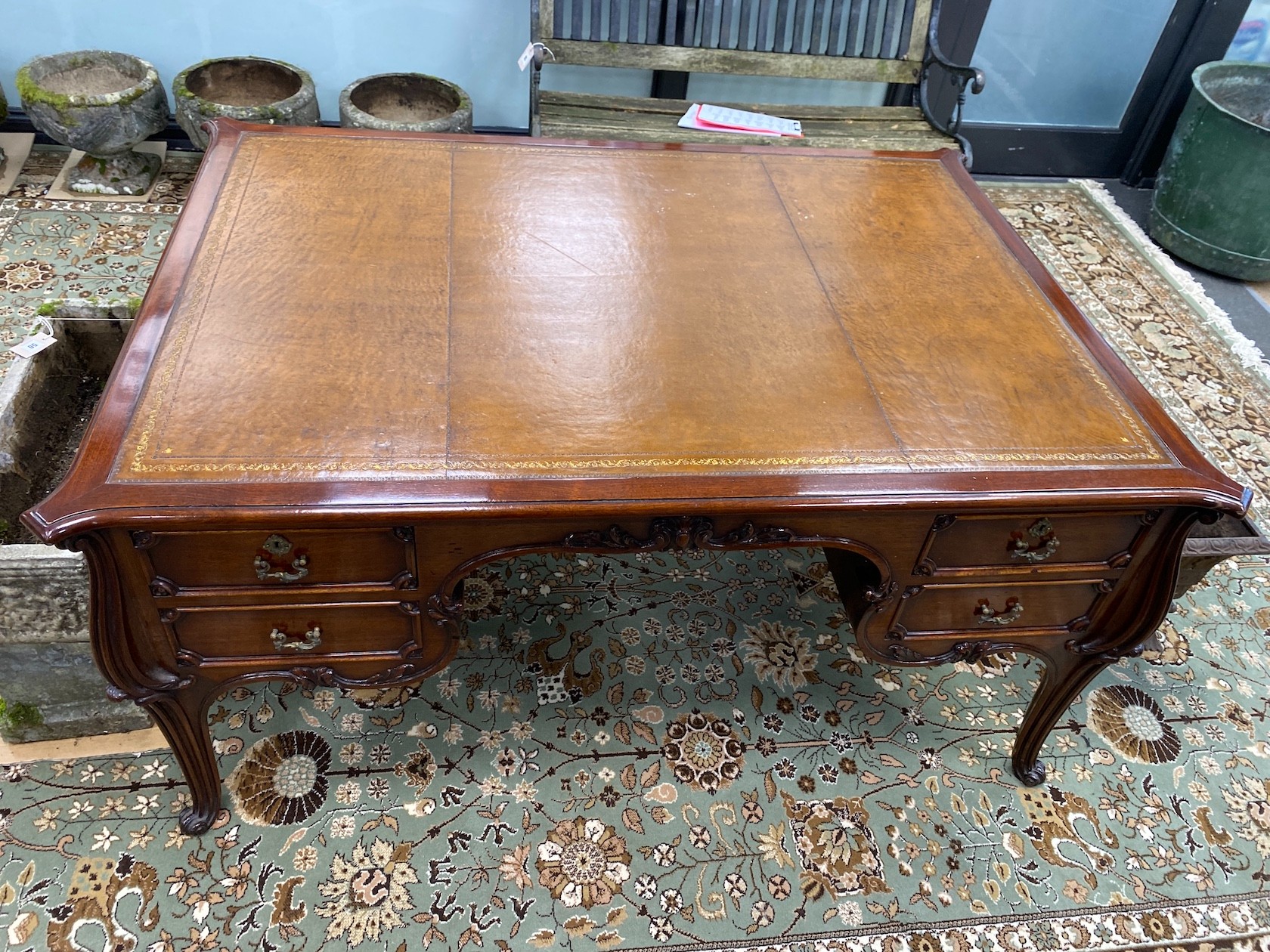 An early 20th century mahogany kneehole partner's desk with tooled tan leather inset top, length 154cm, depth 110cm, height 73cm